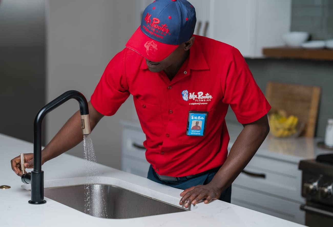 Mr. Rooter Plumber employee in Miami fixing a clogged drain