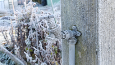 Close-up photo of an outdoor water tap covered in frost. | Mr. Rooter Plumbing of South Jersey