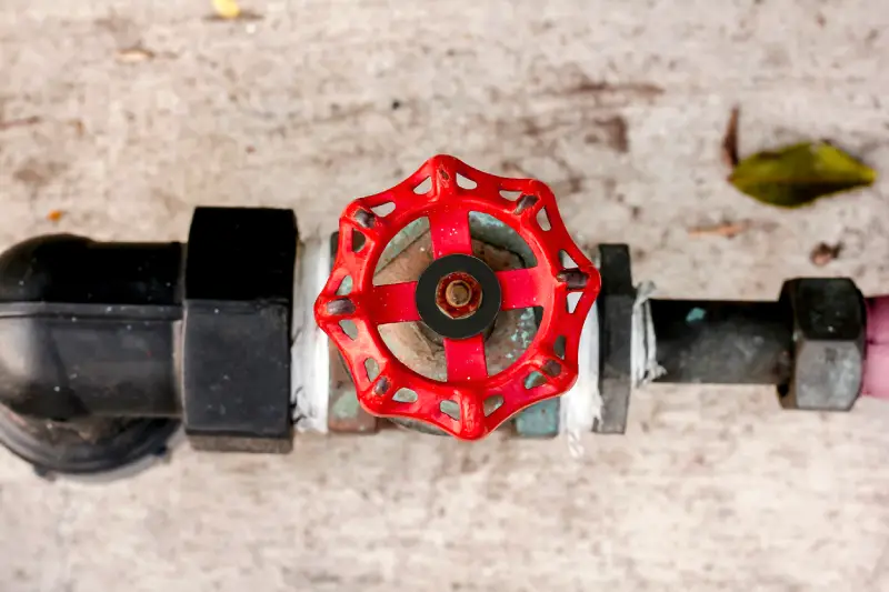 Close-up of a home’s main water shut-off valve in a residential plumbing line, highlighting the importance of knowing its location before a hurricane.